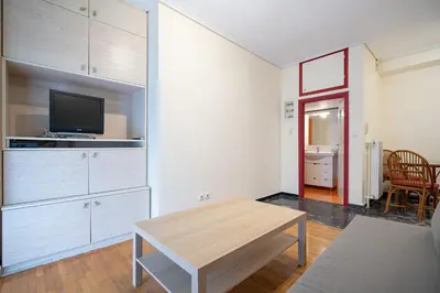a living room with a table and a tv at Mesogion 3 person apartment by MPS in Athens