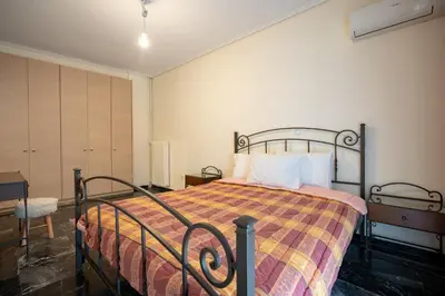a bedroom with a bed with a colorful blanket at Mesogion 3 person apartment by MPS in Athens