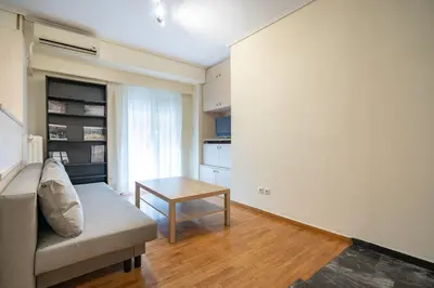 a living room with a couch and a table at Mesogion 3 person apartment by MPS in Athens