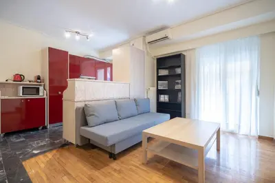 a living room with a couch and a table at Mesogion 3 person apartment by MPS in Athens