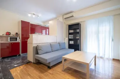 a living room with a couch and a table at Mesogion 3 person apartment by MPS in Athens