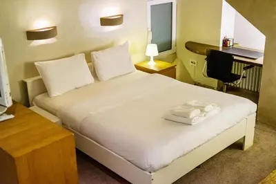 a bedroom with a bed with a desk and a computer at Alia by GK Properties in Athens