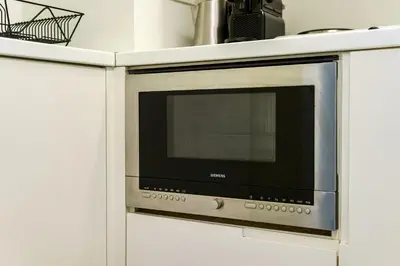 a microwave oven in a white cabinet at Alia by GK Properties in Athens