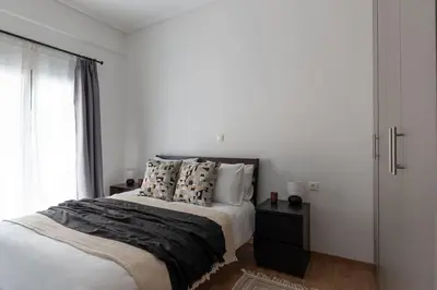 a white bedroom with a bed and a window at Urban Chic Hideaway Near Athens Center & Metro in Athens