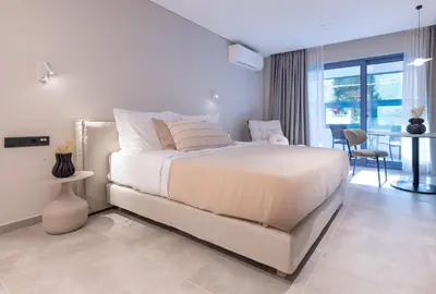 a white bedroom with a large bed and a table at Phaedrus Living Athens Luxury Residences Aurora in Athens