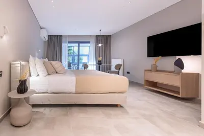 a bedroom with a large bed and a flat screen tv at Phaedrus Living Athens Luxury Residences Aurora in Athens