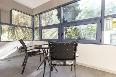 a dining room with two chairs and a table in front of windows at Phaedrus Living Athens Luxury Residences Aurora in Athens