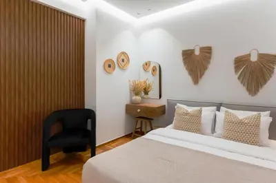 a bedroom with a bed and a black chair at Phaedrus Living Kolonaki Maple Residence in Athens