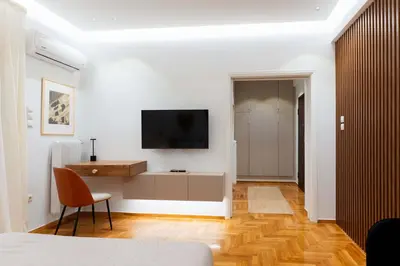 a living room with a television on a white wall at Phaedrus Living Kolonaki Maple Residence in Athens