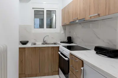 a kitchen with wooden cabinets and a sink and a stove at Phaedrus Living Kolonaki Maple Residence in Athens