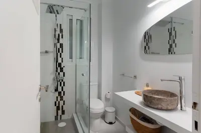 a bathroom with a sink and a glass shower at Phaedrus Living Kolonaki Maple Residence in Athens