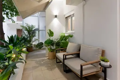 a balcony with chairs and plants in a building at Phaedrus Living Kolonaki Maple Residence in Athens