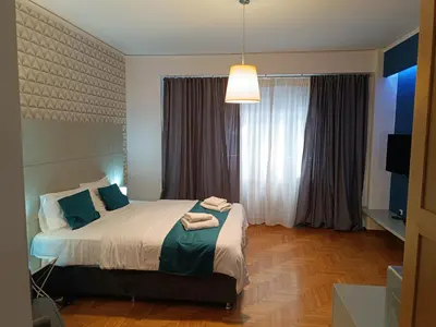 a bedroom with a bed and a large window at Plaka Hideaway Suite in Athens