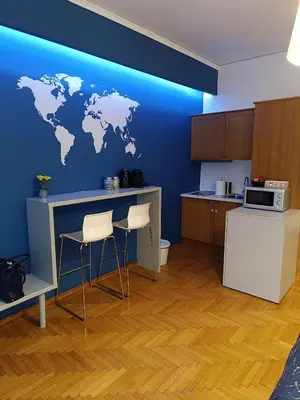 a kitchen with a blue wall with a world mural at Plaka Hideaway Suite in Athens
