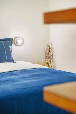 a bed with a blue and white blanket and a lamp at Athens Lycabettus hill, 2 bd apt- Apokafkon in Athens