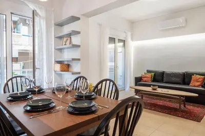 a dining room with a table and chairs and a couch at Athens Lycabettus hill, 2 bd apt- Apokafkon in Athens