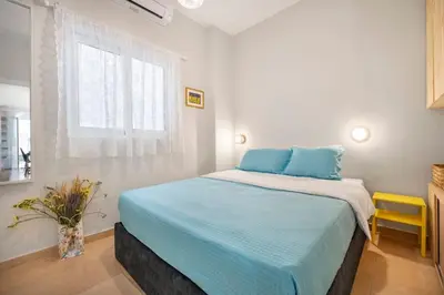 a bedroom with a bed with blue pillows and a window at Athens Lycabettus hill, 2 bd apt- Apokafkon in Athens