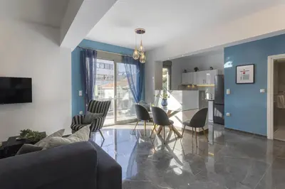 a living room with a couch and a table and chairs at Modern Renovated Apartment in Metaksourgio in Athens
