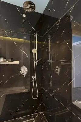 a bathroom with a shower with black marble walls at Modern Renovated Apartment in Metaksourgio in Athens