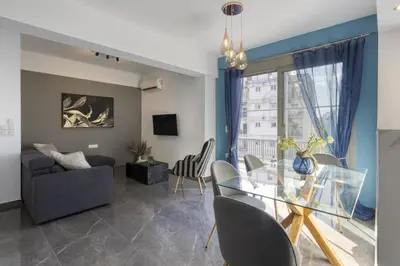 a living room with a glass table and chairs at Modern Renovated Apartment in Metaksourgio in Athens