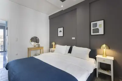 a bedroom with a large bed with a blue blanket at Modern Renovated Apartment in Metaksourgio in Athens