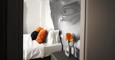 a bedroom with a bed with pillows and a picture of a face at The Solon House-Self check-in in Athens