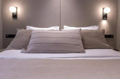 a white bed with two pillows and two lights at Phaedrus Living Athens Luxury Residences Champagne in Athens