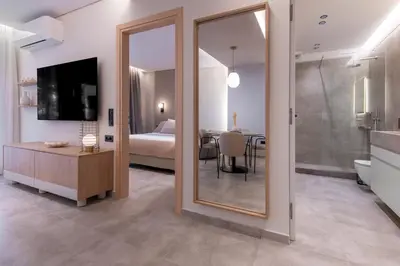 a large mirror in a room with a bedroom at Phaedrus Living Athens Luxury Residences Champagne in Athens