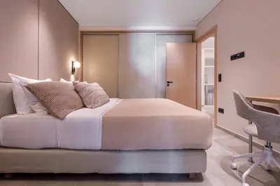 a bedroom with a bed and a desk and a chair at Phaedrus Living Athens Luxury Residences Champagne in Athens