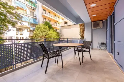 a patio with a table and chairs on a balcony at Phaedrus Living Athens Luxury Residences Champagne in Athens