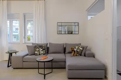 a dog sitting on a couch in a living room at Koukaki Cielo Villa10 -Pvt Yard 3BR 8ppl -10min Metro Acropolis in Athens