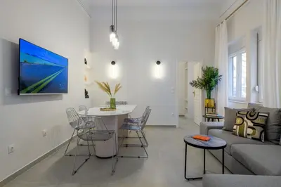 a living room with a couch and a table with chairs at Koukaki Cielo Villa10 -Pvt Yard 3BR 8ppl -10min Metro Acropolis in Athens