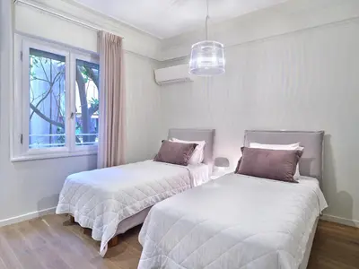 two beds in a white room with a window at 20nty Kolonaki in Athens