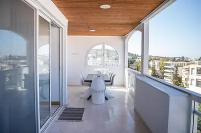 a balcony with a table and chairs in a building at Grand Sea View Apartment 3' from Kavouri Beach in Athens