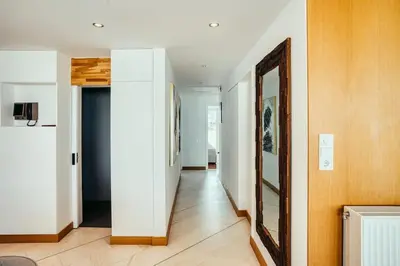a hallway with white walls and a mirror on the wall at Grand Sea View Apartment 3' from Kavouri Beach in Athens