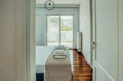 a bedroom with a bed and a clock on the wall at Grand Sea View Apartment 3' from Kavouri Beach in Athens