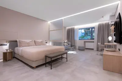 a bedroom with a large bed and a living room at Phaedrus Living Athens Luxury Residences Beige in Athens