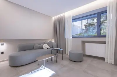a living room with a couch and a table and a window at Phaedrus Living Athens Luxury Residences Beige in Athens