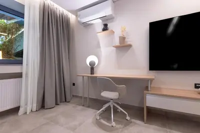 a room with a desk and a tv and a chair at Phaedrus Living Athens Luxury Residences Beige in Athens