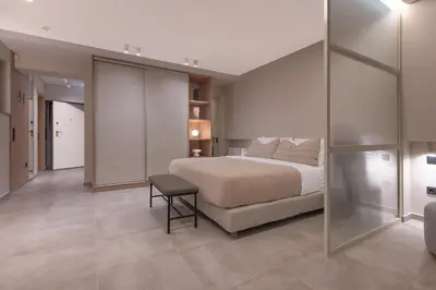 a bedroom with a bed and a glass wall at Phaedrus Living Athens Luxury Residences Beige in Athens