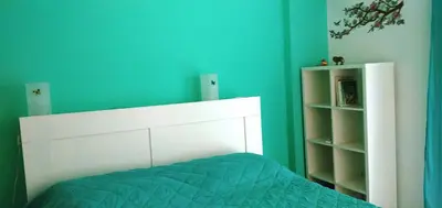 a bedroom with a bed and a blue wall at 1970s Athenean Apartment in Athens