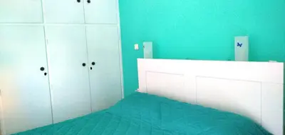 a bedroom with a bed and a blue wall at 1970s Athenean Apartment in Athens