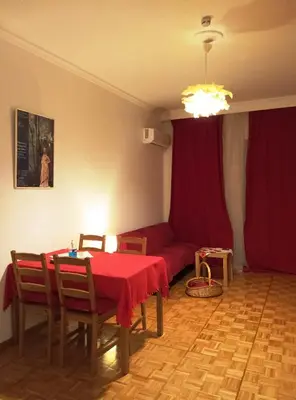a living room with a table and a red couch at 1970s Athenean Apartment in Athens