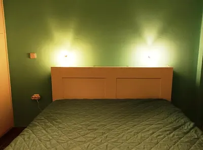 a bedroom with a bed and two lights on the wall at 1970s Athenean Apartment in Athens