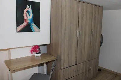 a room with a wooden cabinet and a desk at Cozy Mezonette near City Center Athens near Metro in Athens