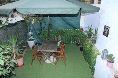 a table and chairs under an umbrella on a patio at Cozy Mezonette near City Center Athens near Metro in Athens