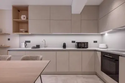a kitchen with white cabinets and a table with chairs at Phaedrus Living Athens Luxury Residences Golden in Athens