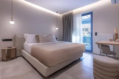 a white bedroom with a bed and a table at Phaedrus Living Athens Luxury Residences Golden in Athens