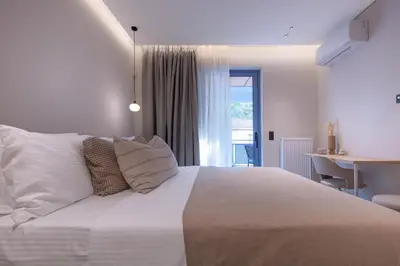 a bedroom with a white bed with a desk and a window at Phaedrus Living Athens Luxury Residences Golden in Athens