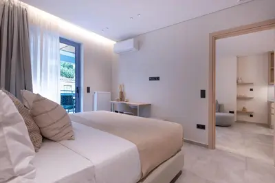 a white bedroom with a large bed and a bathroom at Phaedrus Living Athens Luxury Residences Golden in Athens
